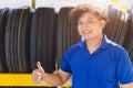 Car tire on shelf with salesman sale agent happy to service in tyre shop. Good quality vehicle tire, people recommended and