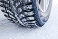 The car tire in the snow close up. Car tracks on the snow. Traces of the car in the snow. Winter tires. Tyres covered with snow at Royalty Free Stock Photo