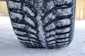 The car tire in the snow close up. Car tracks on the snow. Traces of the car in the snow. Winter tires. Tyres covered with snow at Royalty Free Stock Photo