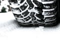 The car tire in the snow close up. Car tracks on the snow. Traces of the car in the snow. Winter tires. Tyres covered with snow at Royalty Free Stock Photo