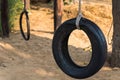 Car tire used as a swing on a tree in the garden. Concept photo of childhood, nostalgia, memory , past, life, retro, vintage, home