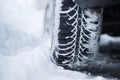 Car tire in winter on the road covered with snow, close up picture