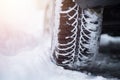 Car tire in winter on the road covered with snow, close up picture