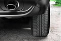 Car tires close-up. Car wheel and exhaust pipe
