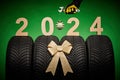 Car tires, new tyres, winter wheels isolated on green background with bow and repairman hand with wrench Royalty Free Stock Photo
