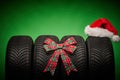 Car tires, new tyres, winter wheels isolated on green background with bow ribbon present Royalty Free Stock Photo