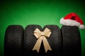 Car tires, new tyres, winter wheels isolated on greenCar tires, new tyres, winter wheels isolated on green christmas background Royalty Free Stock Photo