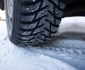 Car tires on winter road covered with snow, Closeup Royalty Free Stock Photo