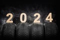 Car tires, winter wheels, isolated new tyres, fog and happy new year 2024 black background Royalty Free Stock Photo