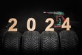 Car tires, winter wheels, isolated new tyres, fog and happy new year 2024 black background Royalty Free Stock Photo