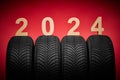 Car tires, winter wheels, isolated new tyres, happy new year 2024 on red background Royalty Free Stock Photo