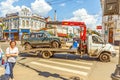 the car tow truck drives a broken car for repairs on Leningradskaya Street on a sunny summer day