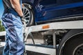 Car Towing Worker Securing a Vehicle on His Truck Royalty Free Stock Photo