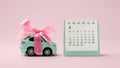 Car toy with bow and calendar on pink background Royalty Free Stock Photo