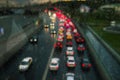 Car traffic in the city in the evening. It is raining outside. Blurred headlights from cars. The movement of cars on the