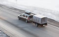 Car with trailer rides on the winter road Royalty Free Stock Photo