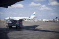 Car and trailer with suitcases and luggage under the plane. Airplanes on the apron. Royalty Free Stock Photo