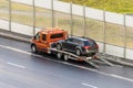 Car is transported on an evacuation tow truck on the highway. Royalty Free Stock Photo