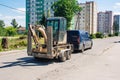 Car is transporting a mini excavator loaded on a trailer