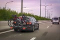 Car transports bicycles on a rack on highway in early morning