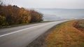 Car traveling on the asphalt road in a rural autumn landscape at sunset Royalty Free Stock Photo