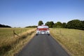 Car traveling down country road Royalty Free Stock Photo