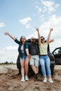 Friends traveling by car enjoy vacation together