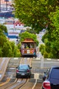 Car and trolley going down steep road in San Francisco, California