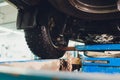 Car on two-post elevator in workshop service station. Royalty Free Stock Photo