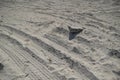 Car Tyre Tracks On The Beach Sand In Perspective. Car Tire Prints On A Road Leading To Beach Covered In Sand. Wheel Tracks On The