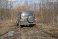 The car UAZ-Patriot is stuck in the mud while crossing the forest belt