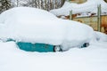 Car under the snow. A lot of snow after a snowfall. The car is completely covered with snow. Cold and snowy climate. Royalty Free Stock Photo