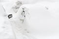 Car under the snow. Lots of snow and big snowdrifts on the street.