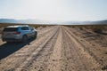 Car on unpaved road in desert. Death Valley National Park, sunny autumn morning Royalty Free Stock Photo