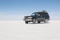 Car on the Uyuni Salar in Bolivia. Blue Sky and white salt background Royalty Free Stock Photo