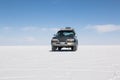 Car on the Uyuni Salar in Bolivia. Blue Sky and white salt background Royalty Free Stock Photo
