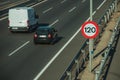 Car and van on highway and SPEED LIMIT signpost in Madrid