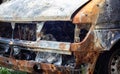 The car was completely destroyed by fire. Abandoned, burnt and rusty car by the road. Cars were on fire in the parking lot. War of Royalty Free Stock Photo