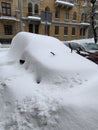 The car was covered with snow in the parking lot. Cars under a l Royalty Free Stock Photo