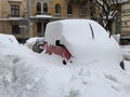 The car was covered with snow in the parking lot. Cars under a large layer of snow. Snowfall on the streets of Europe Royalty Free Stock Photo