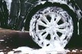 car wash with active foam soap. cleaning wheel tire. Royalty Free Stock Photo