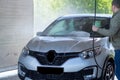 Car wash on a contactless car wash. A man washes the car. Put the car in order