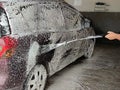 Car wash, foam jet floods the car Royalty Free Stock Photo