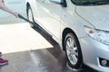 Car wash. A man washes his car with a high pressure water jet.