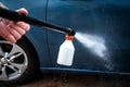 Car wash process. Spray foam bubble shampoo on the car surface Royalty Free Stock Photo