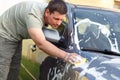 Car wash self service - man washing car with a sponge and foam Royalty Free Stock Photo