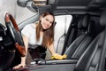 Car wash service, girl worker cleaning interior modern microfiber and console auto