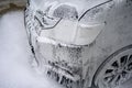 Car wash with soap. Black car covered by foam. Royalty Free Stock Photo