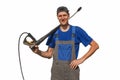 A car wash worker with equipment isolated on a white background. The cheerful guy in overalls looks in the camera and smiles.