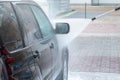 Car is washed with a strong water jet at a self-service car wash